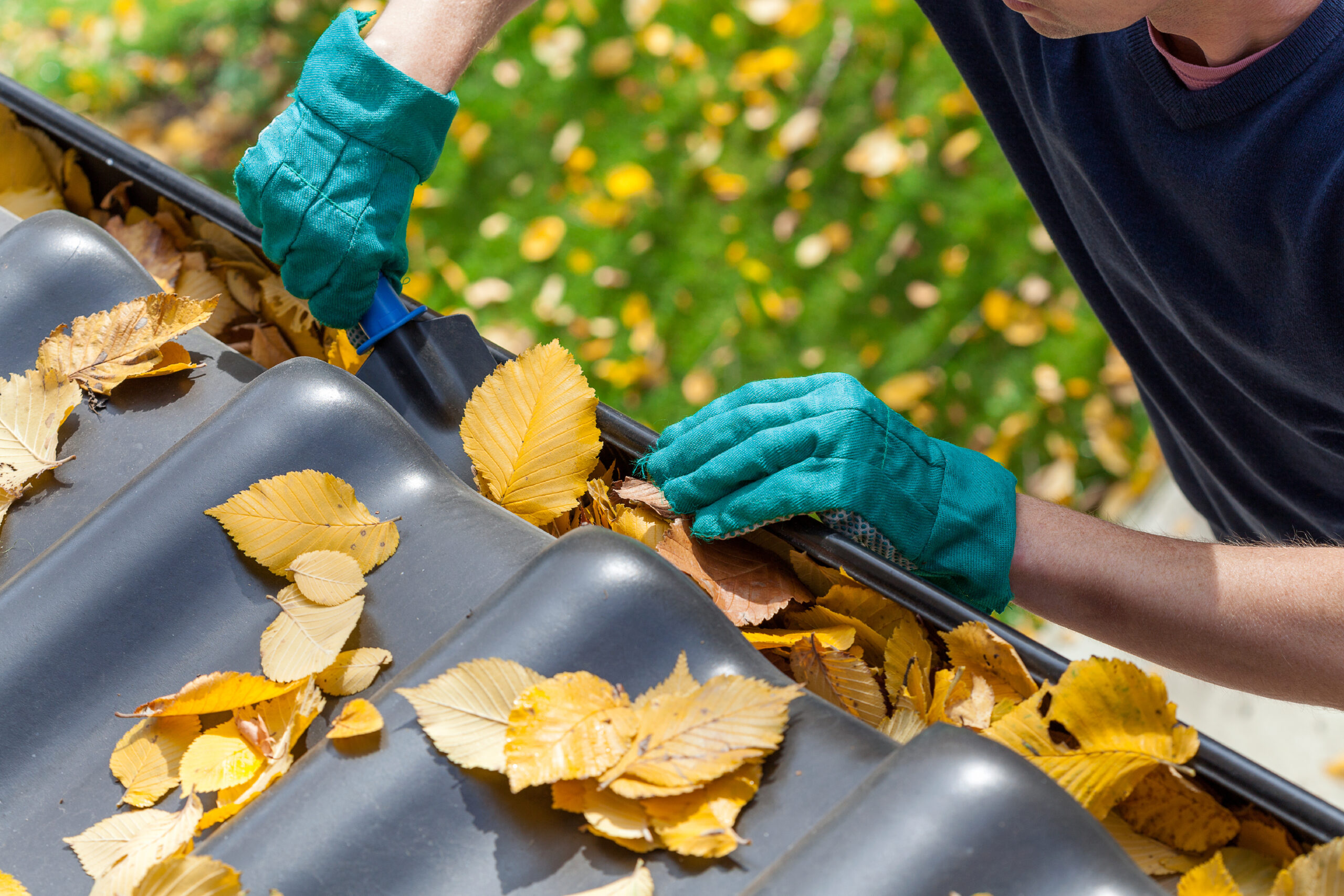 person hand scooping gutters